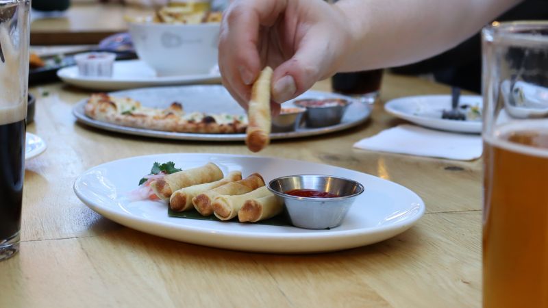 A hand grabbing a lumpia.